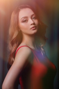 Siyah bir arka plan üzerinde poz Kırmızı elbiseli çekici esmer.