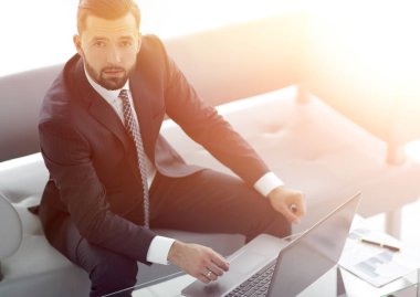 mali grafikler ile bir dizüstü bilgisayar üzerinde çalışan iş adamı