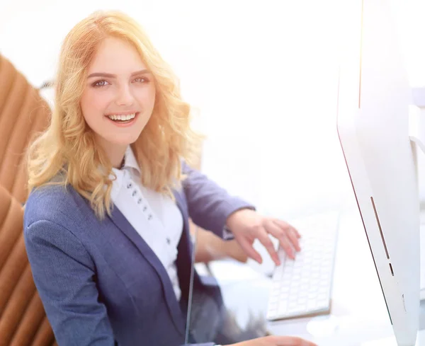 smiling business woman sitting behind a Desk