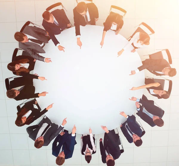 Equipo de negocios indica el centro de la mesa redonda . — Foto de Stock