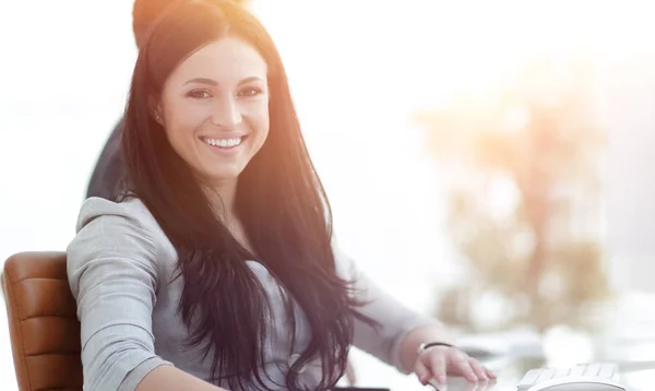 Exitosa mujer de negocios sonriente sentada en el escritorio —  Fotos de Stock