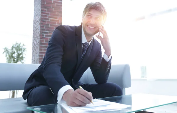 Uomo d'affari con uno smartphone sul posto di lavoro — Foto Stock