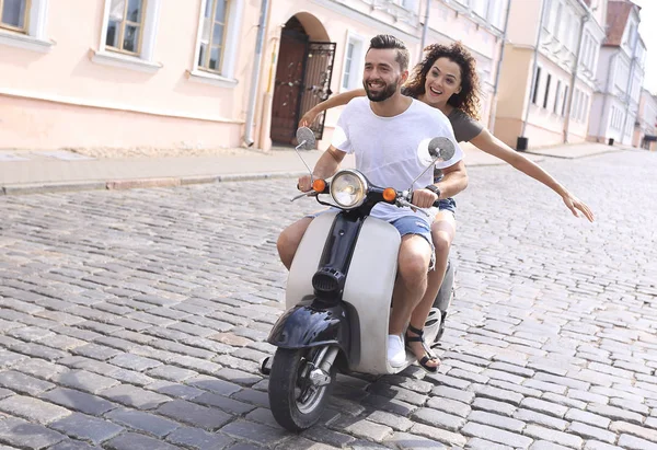 Glückliches junges Paar, das Spaß auf einem Roller hat — Stockfoto