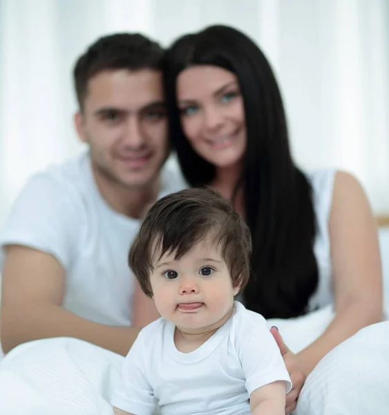 Feliz pareja e hijo sentado en la cama —  Fotos de Stock