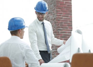 yeni bir projeyi tartışmak üzere mimar ve inşaat ustabaşı