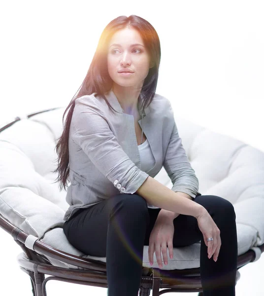 Junge Frau sitzt in einem runden kuscheligen weichen großen Stuhl. — Stockfoto