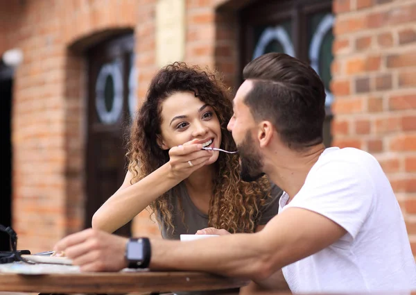 Fiatal pár élvezi a kávét egy utcai kávézó és nevetve — Stock Fotó