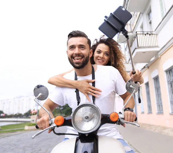 スマート フォンで selfie を屋外に作るスクーターに幸せなカップル — ストック写真