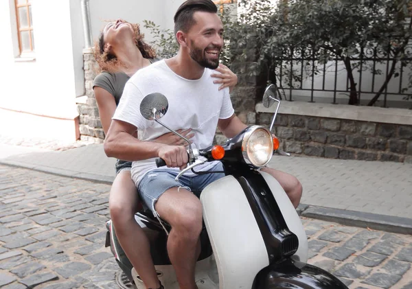 Stylish young couple sits a scooter in the street. — Stock Photo, Image