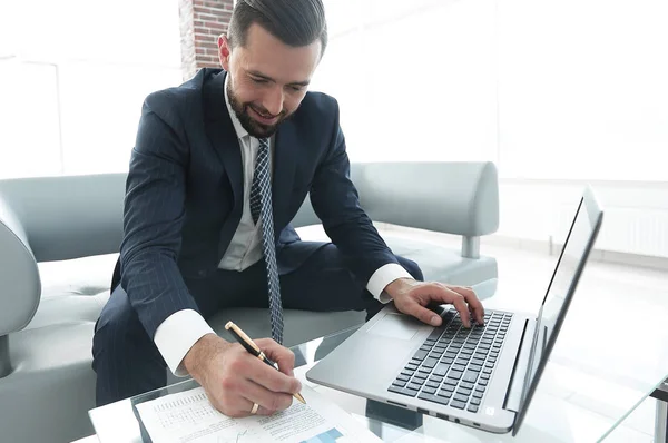 Hombre con estilo que trabaja en el ordenador portátil y toma notas en el cuaderno —  Fotos de Stock