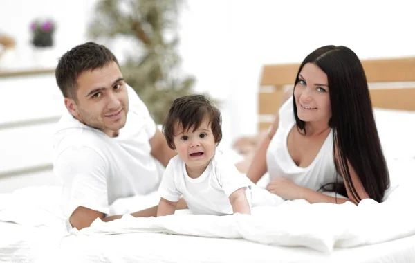 Portrait de jeune famille heureuse couchée ensemble — Photo