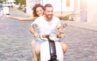 mutlu genç bir çift bir scooter üzerinde eğleniyor