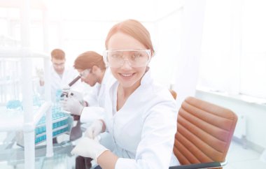 Araştırmacı kontrol test tüpleri, kadın koruyucu gözlük takıyor.