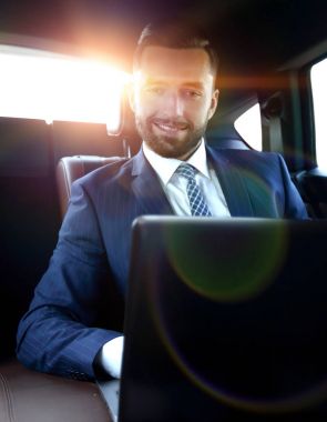 Bir arabanın arka koltuğunda oturan başarılı adam