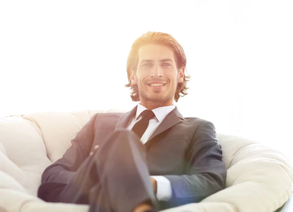 Guapo hombre de negocios sentado en un gran sillón acogedor . —  Fotos de Stock