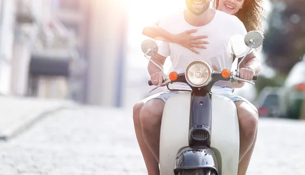 Szczęśliwa para młodych, jazda skuterem w mieście na słoneczny dzień — Zdjęcie stockowe