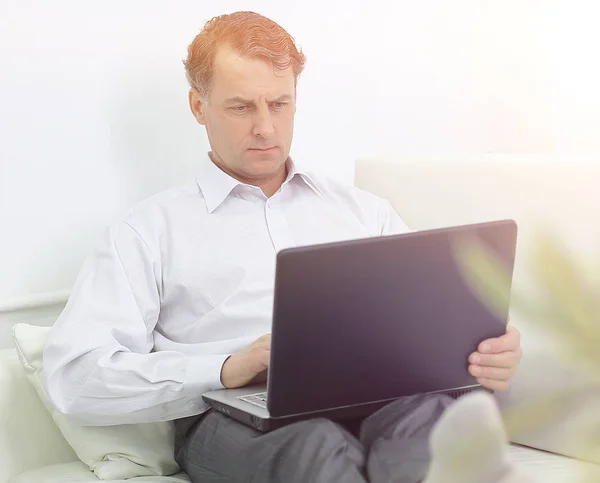 Zakenman die op laptop werken zittend in een hotelkamer — Stockfoto