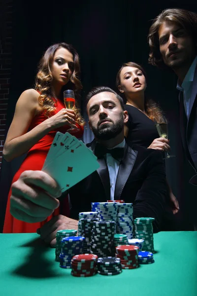 Концентровані чоловіки та жінки грають у покер у запасі казино