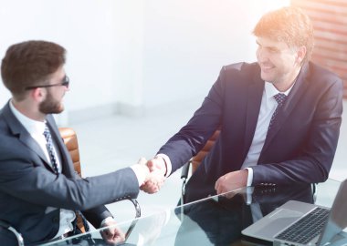 İş adamları el sıkışır, masada otururlar. .