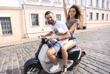 Genç çift bir scooter sürme ve having fun