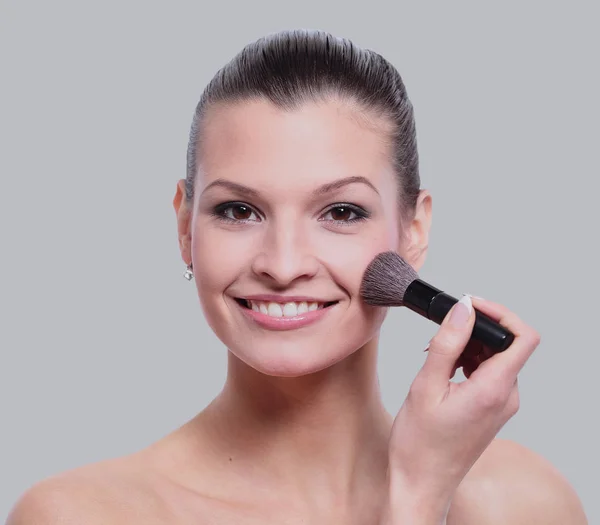 Woman applying dry cosmetic tonal foundation on the face using m — Stock Photo, Image