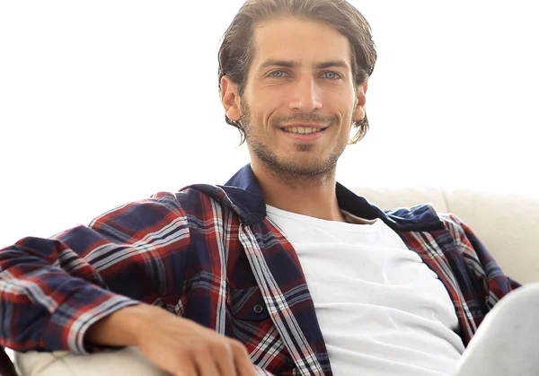 Primer plano de un chico sonriente acariciando a su perro mientras está sentado en un sillón grande . — Foto de Stock