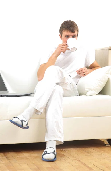 Schöner, lässiger Mann sitzt auf der Couch und trinkt zu Hause Kaffee. — Stockfoto