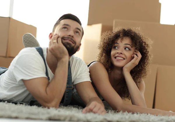 Pareja feliz en el fondo de cajas de cartón — Foto de Stock