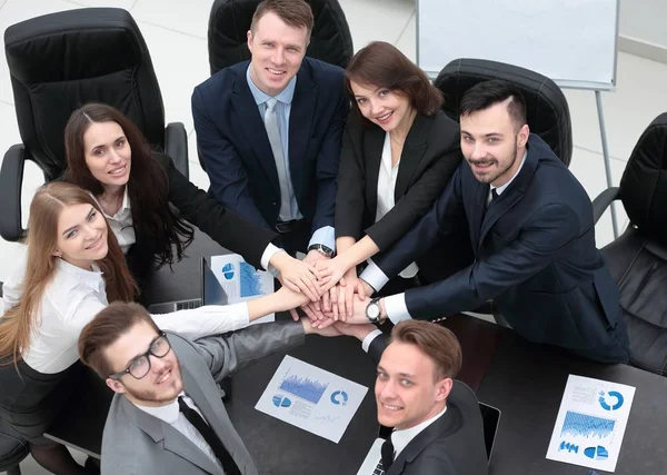 Бізнес-команда з руками, закріпленими разом на столі — стокове фото