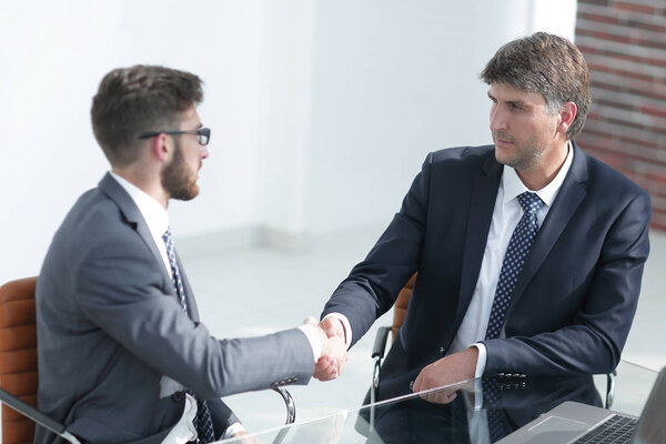 Business people handshake, sitting at the table .