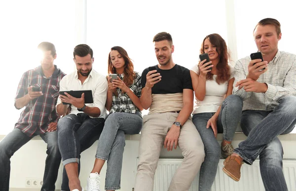 Young people in casual clothes using gadgets — Stock Photo, Image