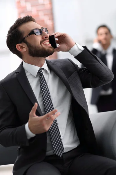 Pohledný podnikatel mluvit na mobilním telefonu v kanceláři — Stock fotografie