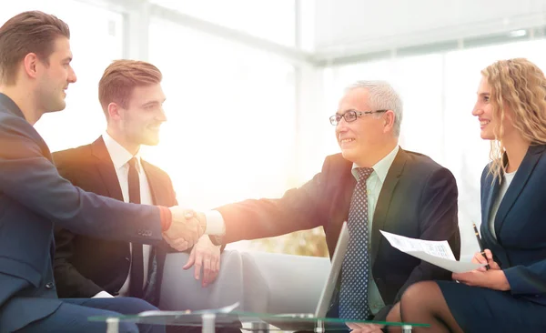 Partners concluding deal and shaking hands in the presence of team members — Stock Photo, Image