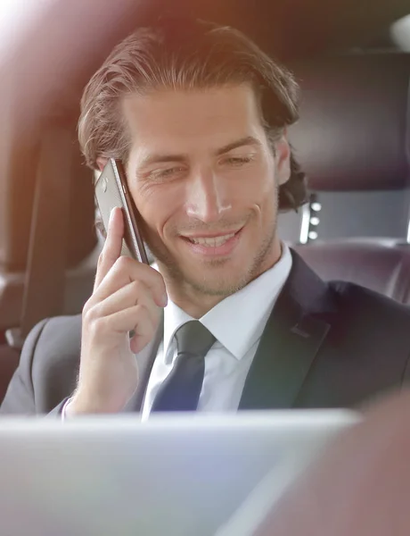Красивый бизнесмен, использующий мобильный телефон в машине . — стоковое фото