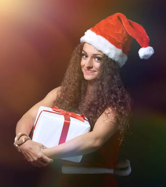 Schöne Frau mit einer Weihnachtsgeschenkschachtel auf schwarzem Hintergrund — Stockfoto