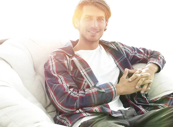 modern adam büyük bir rahat sandalyede oturuyor.