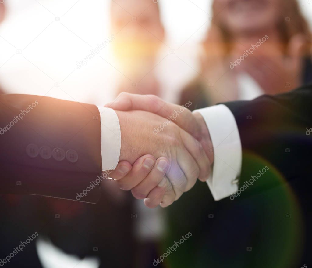 closeup of handshake of business partners on background of emplo