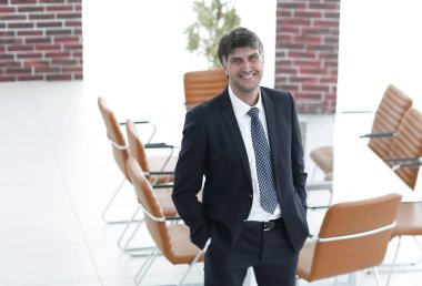 Bir boş toplantı odasında duran iş adamı