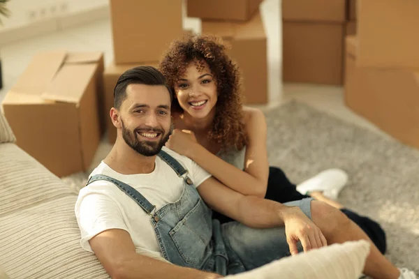 Unga par som sitter på golvet i en ny lägenhet — Stockfoto