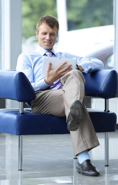 Zakenman in pak rusten in fauteuil op kantoor — Stockfoto