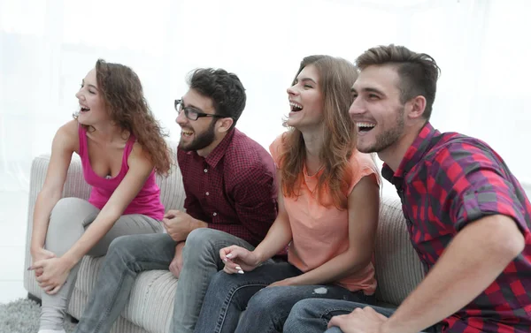 Groupe de jeunes gens souriants assis sur le canapé — Photo