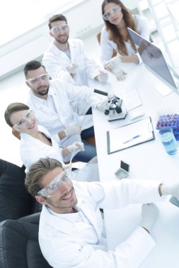 İşyerinde oturan top.modern genç bilim adamı üzerinden görüntülemek