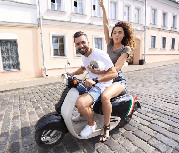 Alegre jovem casal montando uma scooter e se divertindo — Fotografia de Stock