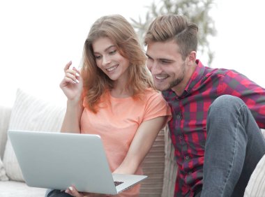 oturma odasında dizüstü bilgisayarda bir Tv programı izlerken onun kız arkadaşı ile genç adam