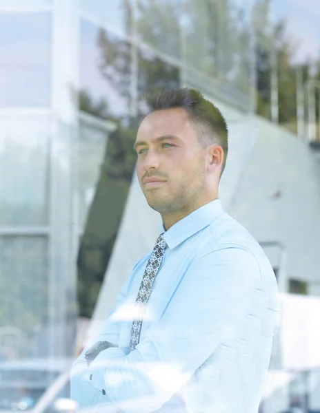 Vue de derrière glass.confident homme d'affaires regardant par la fenêtre de son bureau — Photo