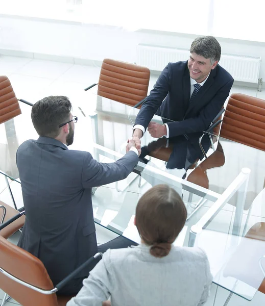 Handslag över bordet med finansiella partner — Stockfoto