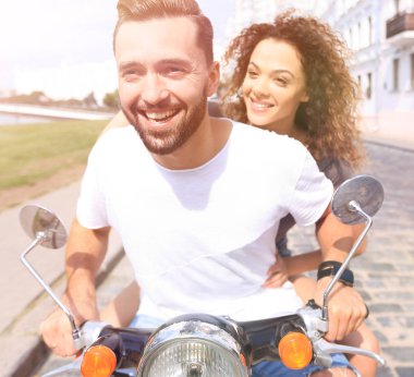 Mutlu çift sürme vintage scooter açık havada.