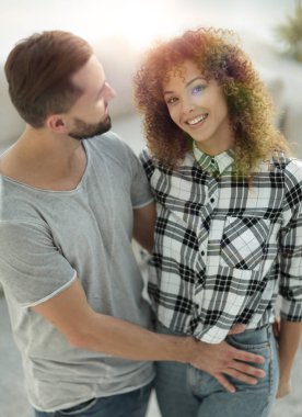 mutlu genç çift birbirlerine sarılıyor.