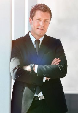 office penceresinde yakınındaki ayakta ciddi iş adamı.