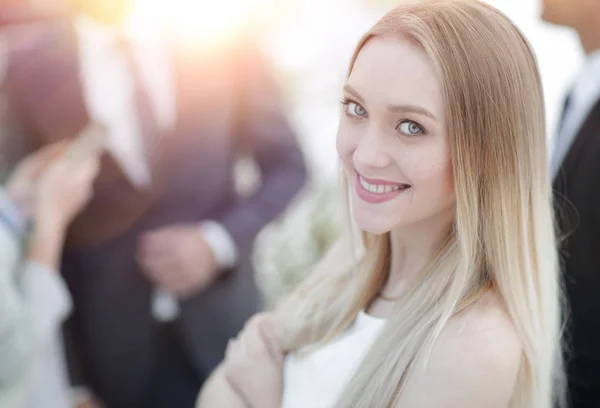 Close-up van een jonge vrouw in het kantoor op de achtergrond van collega 's. — Stockfoto